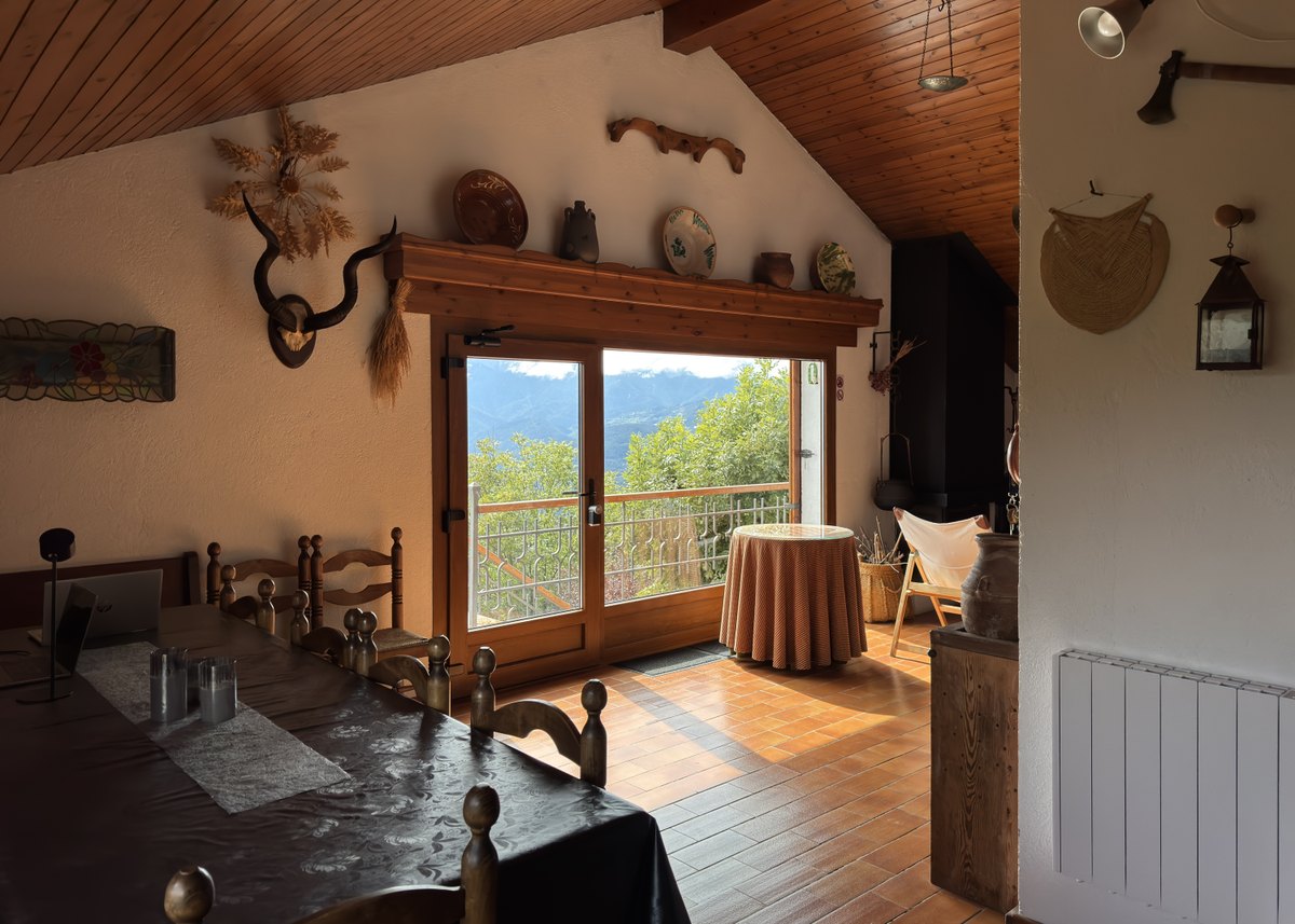 La sala de estar abierta a la terraza, con el comedor y las vistas al valle